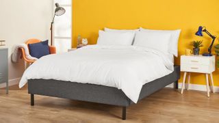 The Nectar Duvet on a mattress on a bed frame in a yellow bedroom