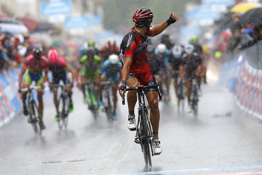 Philippe Gilbert of the BMC team celebrates as he crosses the finish line under heavy rain to win the 12th stage of the 98th Giro d'Italia.