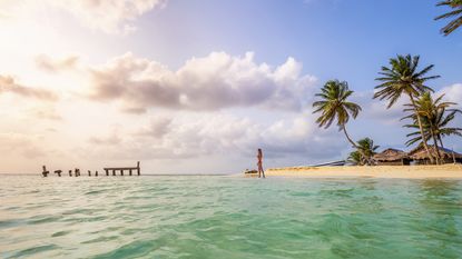 Woman on a deserted island, like the ones that can be rented as private islands on airbnb