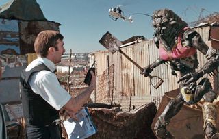 A still from District 9 in which main character Piet confronts an alien.
