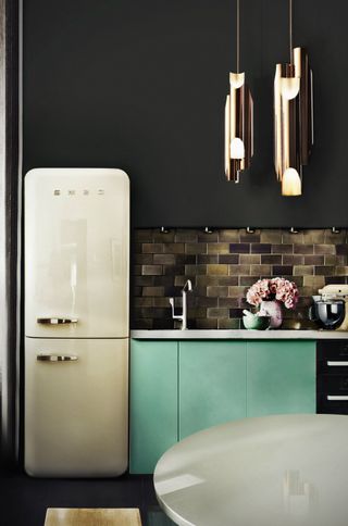 small kitchen with fridge, dark cupboards and a pop of green