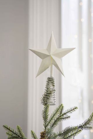 A cotton paper warm white star-shaped Christmas tree topper