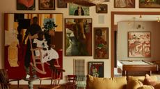 Eclectic, warm-toned gallery wall of a living room designed by Pierce and Ward Design Studio 