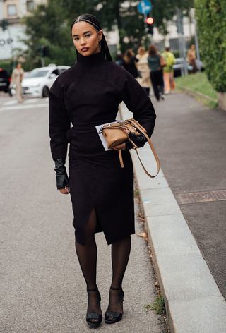 Milan fashion week spring 2025 street style photo of a woman wearing funnel neck trend