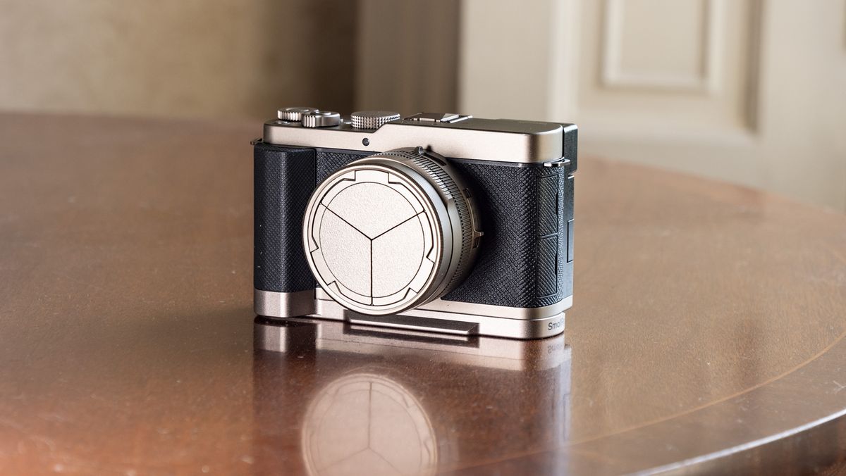 Titanium Gold special edition of the Panasonic Lumix L10 compact camera, on an antique wooden table