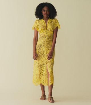 a model wears a yellow lace midi dress with short sleeves