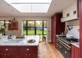 cherry red kitchen with vintage style oven and a copper tap sink built in the kitchen island