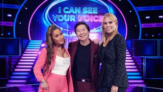 Panelist Adrienne Bailon, host Ken Jeong and panelist Cheryl Hines on stage in I Can See Your Voice