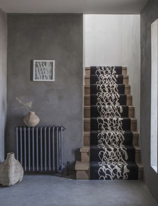 Hallway with grey walls and floor and wooden staircase with runner from Alternative Flooring