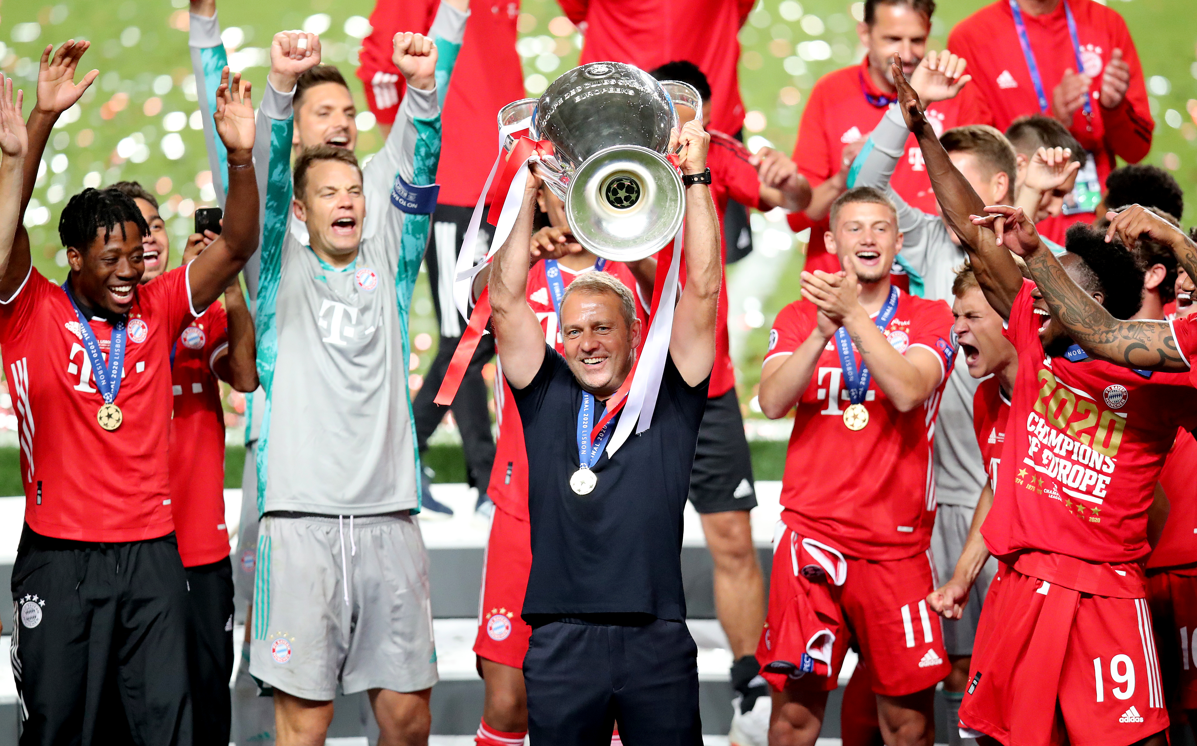 Hansi Flick celebrates with the Champions League trophy after Bayern Munich's win over Paris Saint-Germain in the 2020 final.