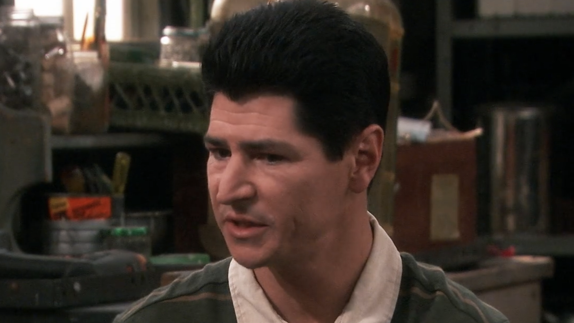 Michael Fishman's D.J. Conner sitting in home garage in front of a tool bench talking to Dan in Roseanne Season 10
