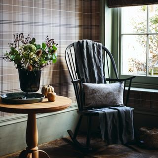 Tartan accent wallpaper in room with rocking chair and side table