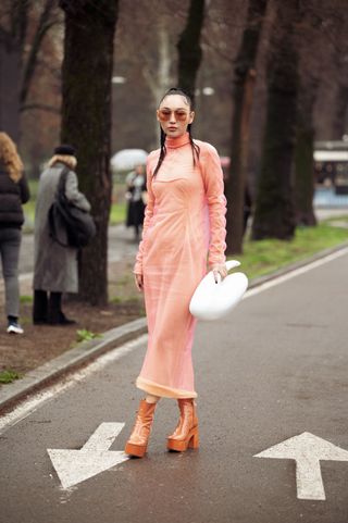 a woman wears a coral dress