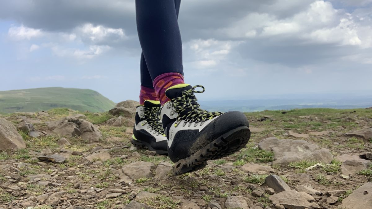 Close up of a hiker&#039;s feet walking across a rocky summit in the Danner Crag Rat EVO boots