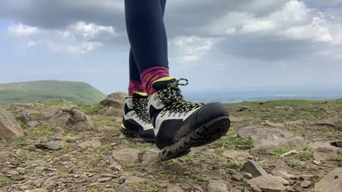 Close up of a hiker's feet walking across a rocky summit in the Danner Crag Rat EVO boots