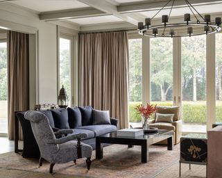 living room with glass doors, neutral color scheme and dark blue sofa