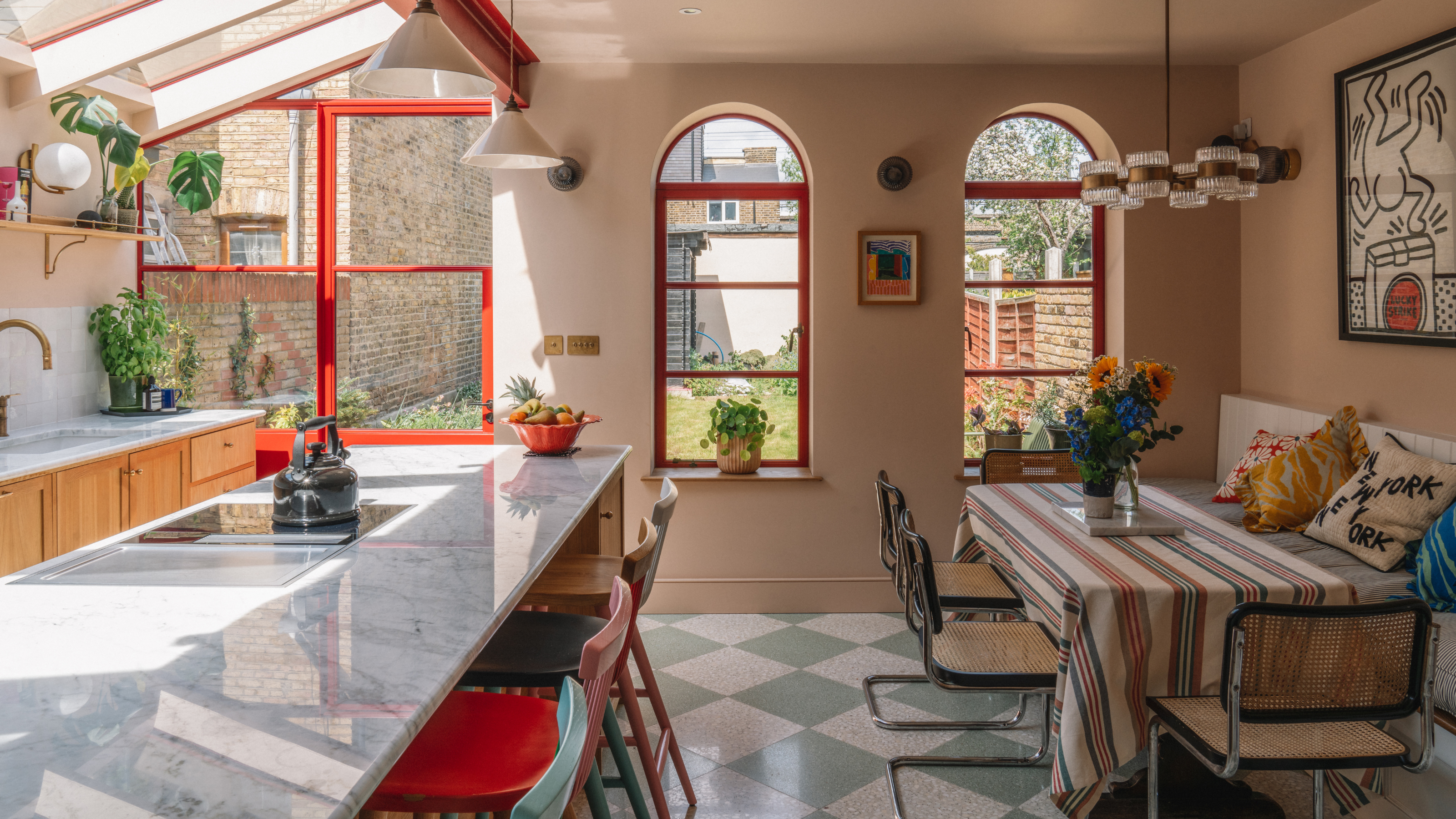 beautiful kitchen extension with red accents and blue and white checkerboard tile floors