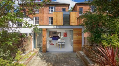 A home with a kitchen extension. You can see a view of the garden with plants and the outside of the house. 