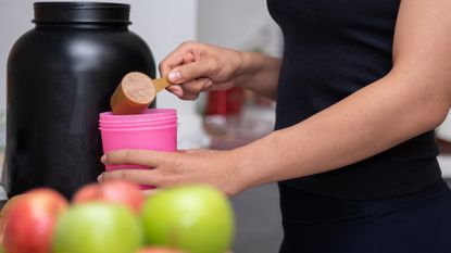 Woman scooping whey protein