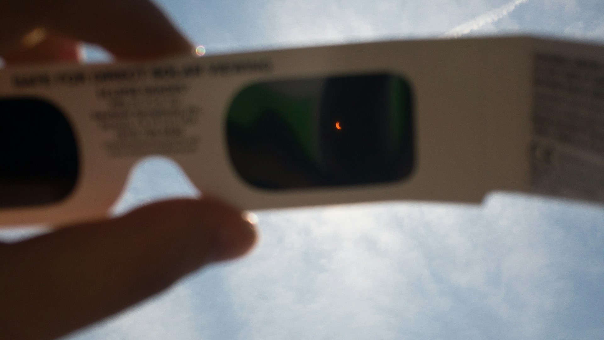 Holding eclipse glasses up to view the 2017 total solar eclipse