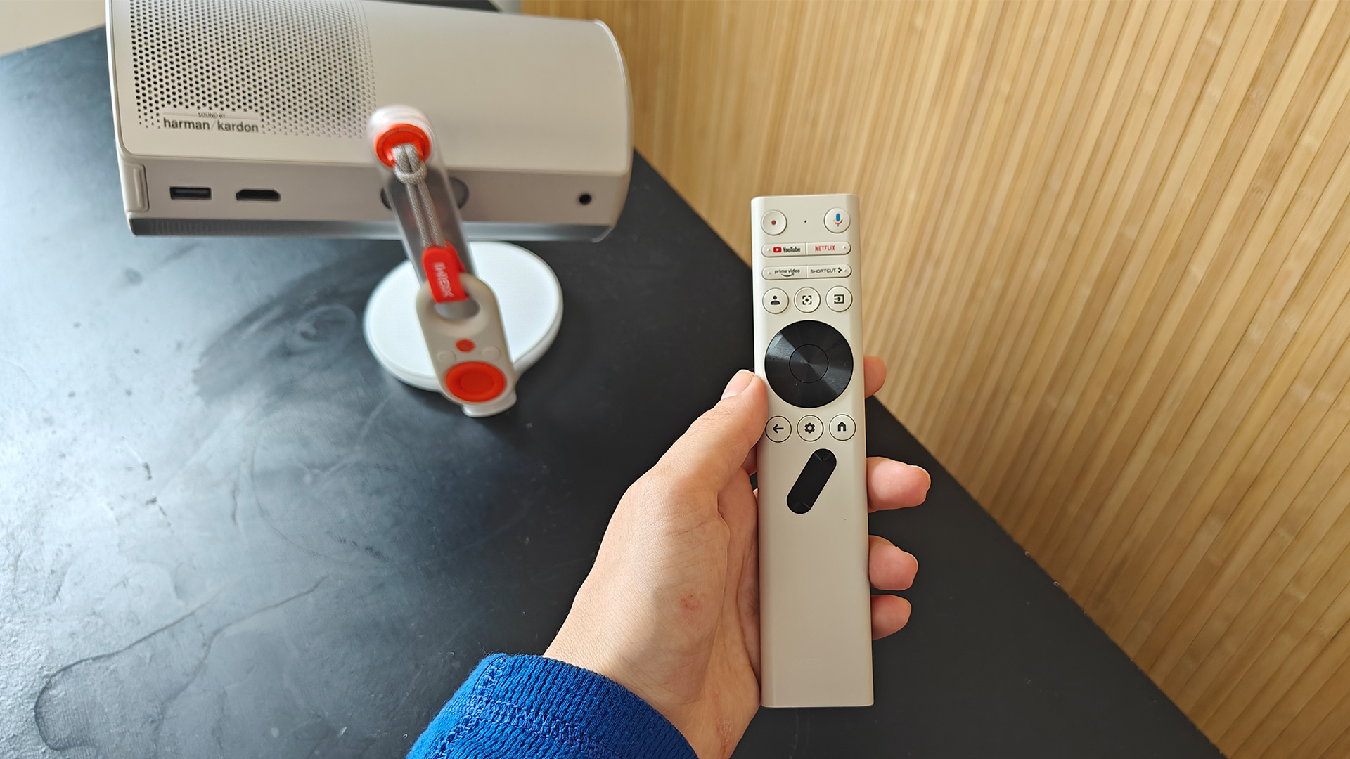 Xgimi MoGo 4 portable projector with remote control held in hand