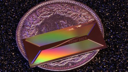 An iridescent colored rectangle on top of a purple coin.
