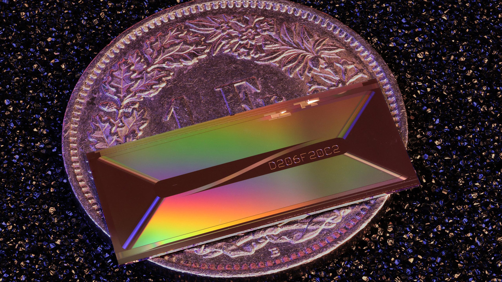 An iridescent colored rectangle on top of a purple coin.