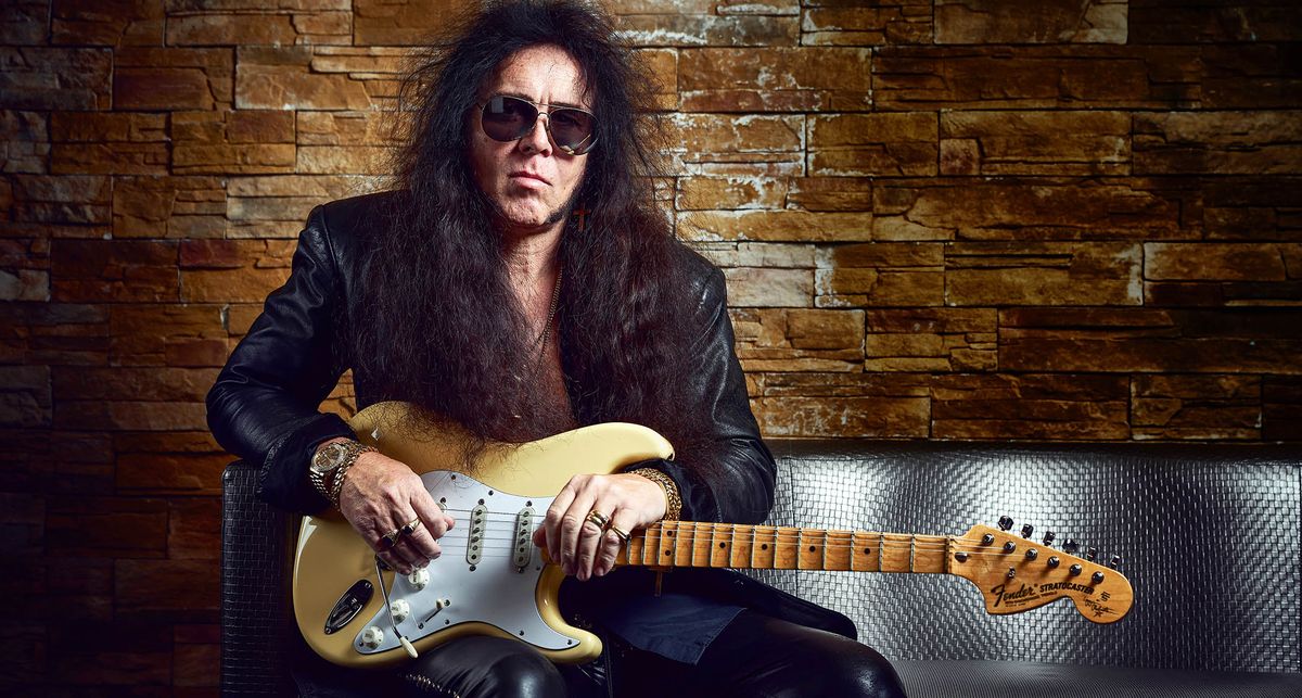 Yngwie Malmsteen is wearing aviator sunglasses and holds his signature Fender Stratocaster – a guitar that he promises you is the best you will ever find.