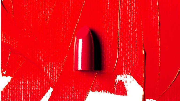 Red lipstick swatch and lipstick bullet on white background