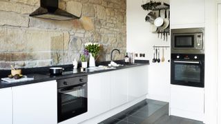 Exposed stone in a kitchen with modern units from Howdens