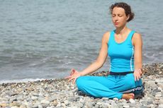 woman meditating on beach