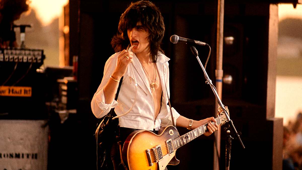 Joe Perry performing live onstage, playing Gibson Les Paul guitar, using Talk Box guitar effect pipe