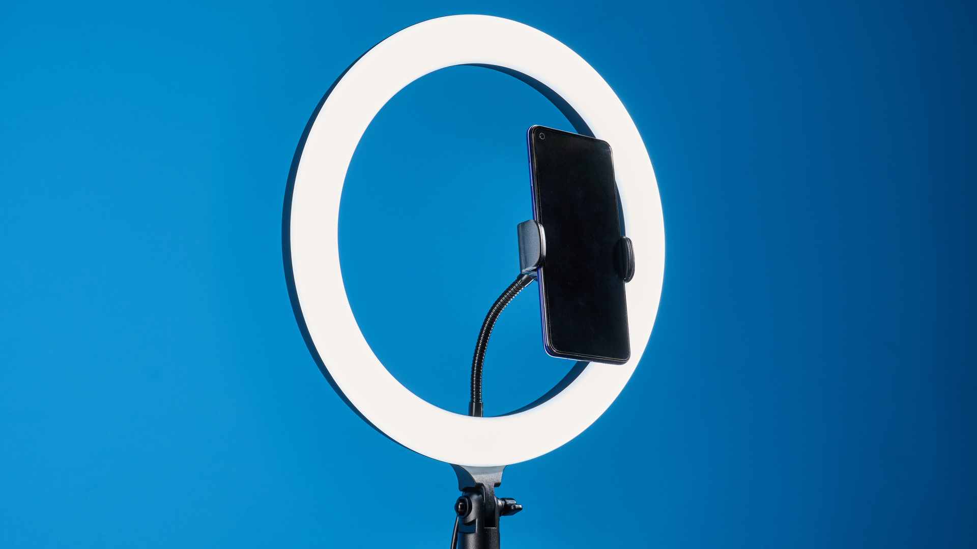 Godox 12-inch ring light photographed in front of a blue background with an iPhone on the phone mount.