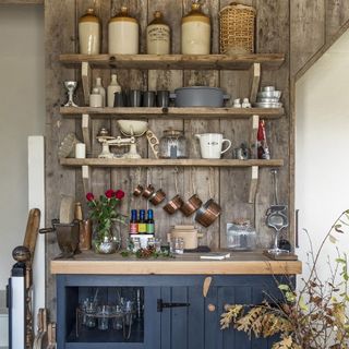 Rustic wood paneling with wall shelves and blue cabinets