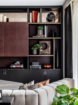 Asymmetrical shelving styled with gold and black decor