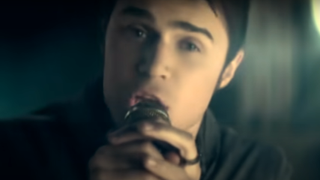 Kris Allen singing "Live Like We're Dying" in the music video.