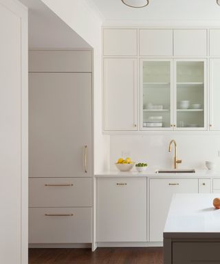 modern minimalist kitchen with white cabinets, brass hardware and gold tap