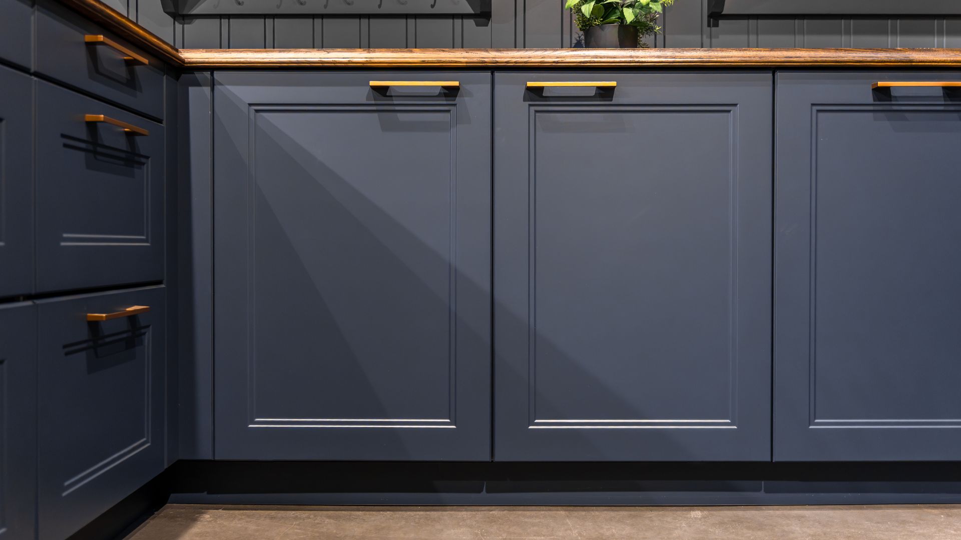 picture of deep navy kitchen cabinets with gold handles