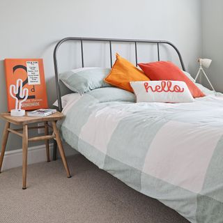 Bedroom with metal bedframe and hello cushion