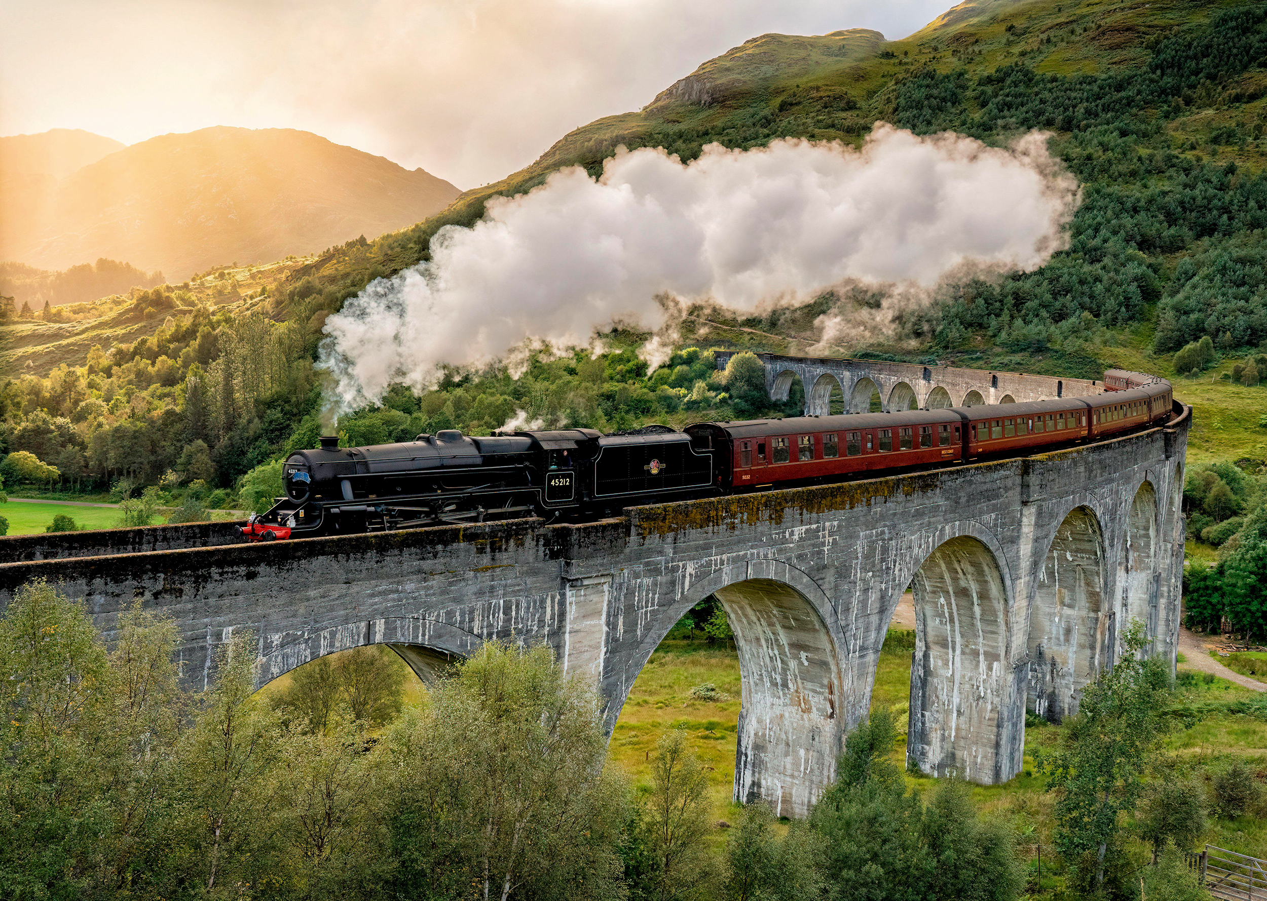 The Jacobite steam train crosses the Glenfinnan viaduct in the Scottish Highlands, a trip made famous by the Harry Potter movies