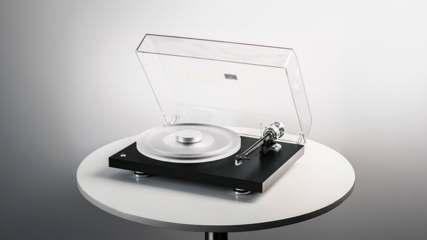 Pro-Ject Debut Reference 10 promotional image of the turntable sitting on a white circular table against a graded grey background