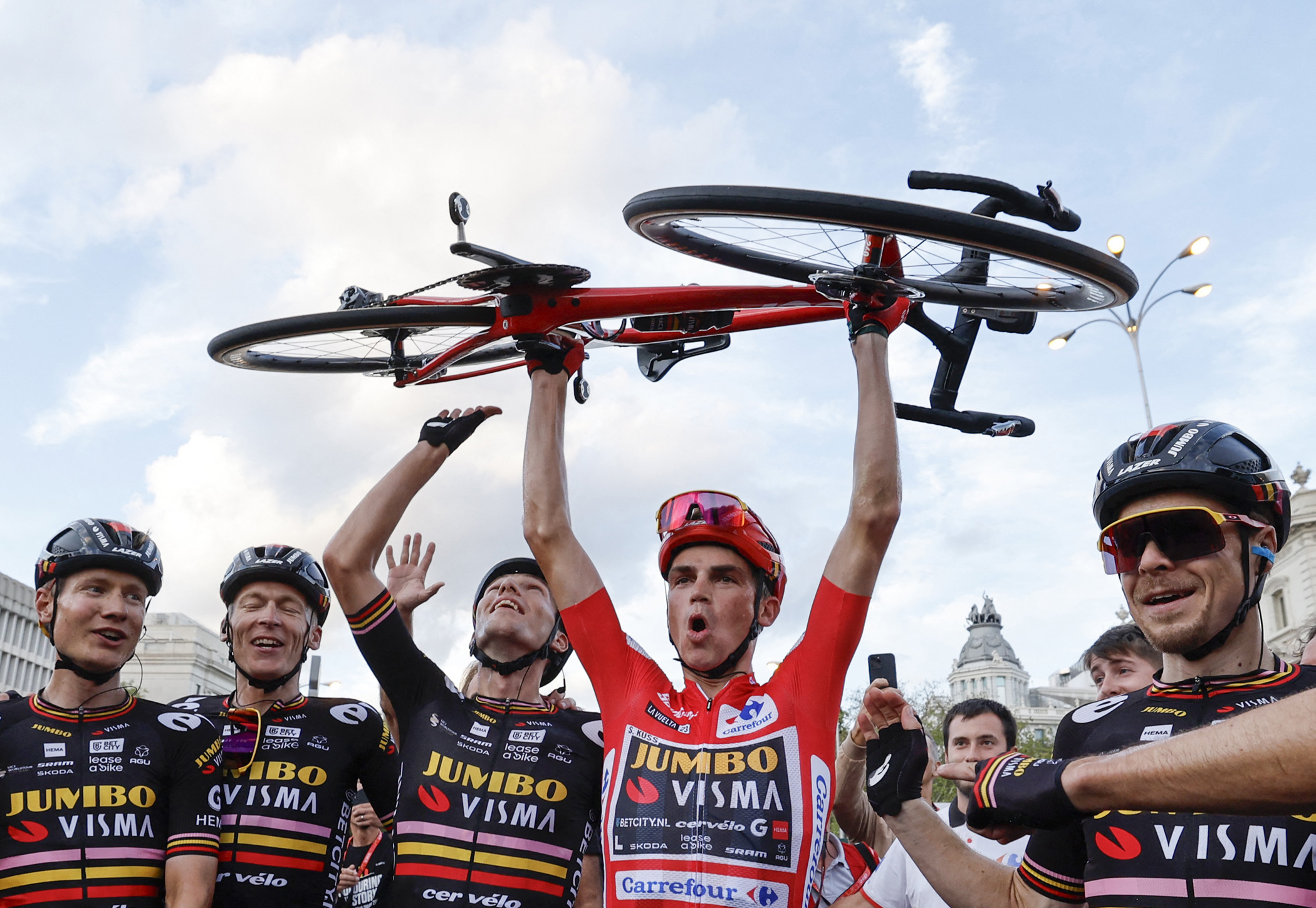 TOPSHOT - Overall leader Team Jumbo-Visma's US rider Sepp Kuss (C) celebrates with teammates winning after the 21st and last stage of the 2023 La Vuelta cycling tour of Spain, a 101,1 km race between the hippodrome of La Zarzuela and Madrid, on September 17, 2023. American rider Sepp Kuss claimed his first Grand Tour victory in the Vuelta a Espana in Madrid, as his team Jumbo-Visma completed an unprecedented treble. (Photo by OSCAR DEL POZO / AFP) (Photo by OSCAR DEL POZO/AFP via Getty Images)