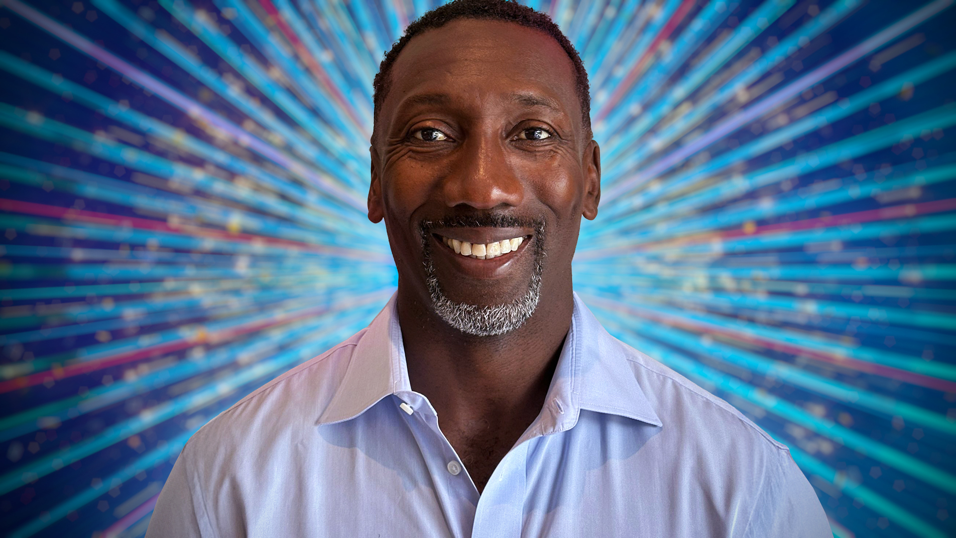 Jimmy Floyd Hasselbaink smiling for the camera with a blue sparkly background behind her.