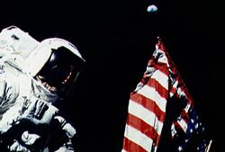 In this Apollo 17 onboard photo, Mission Commander Eugene A. Cernan adjusts the U.S. flag deployed upon the Moon during the December 1972 lunar landing mission, which marked the last of NASA&#039;s Apollo Moon landings.