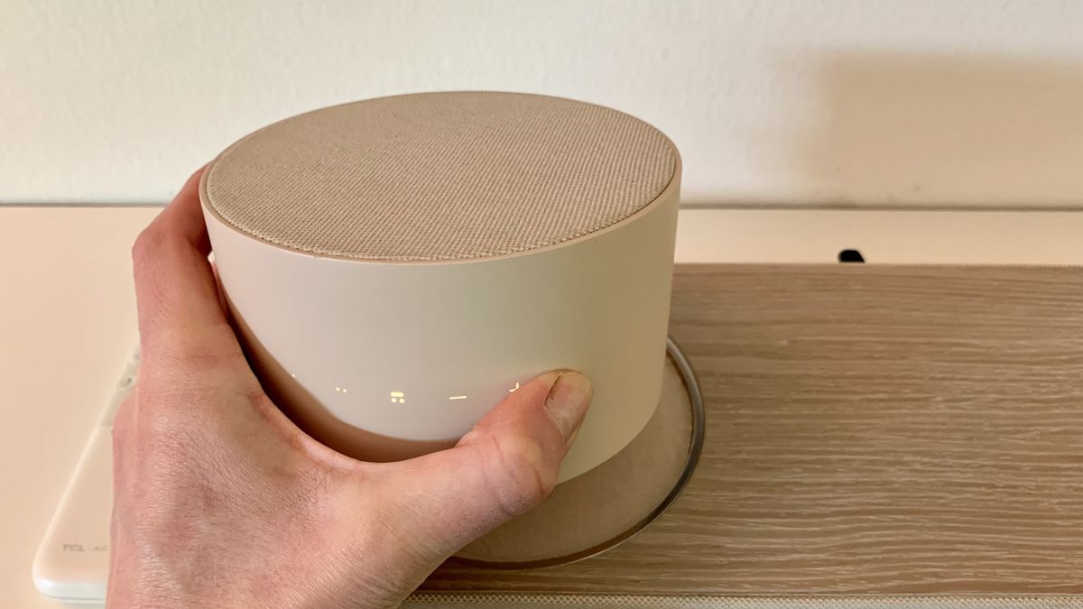 TCL Art TV's soundbar satellite speaker held in a hand