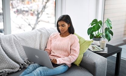Woman on couch using the Dell XPS 17 (9720) laptop