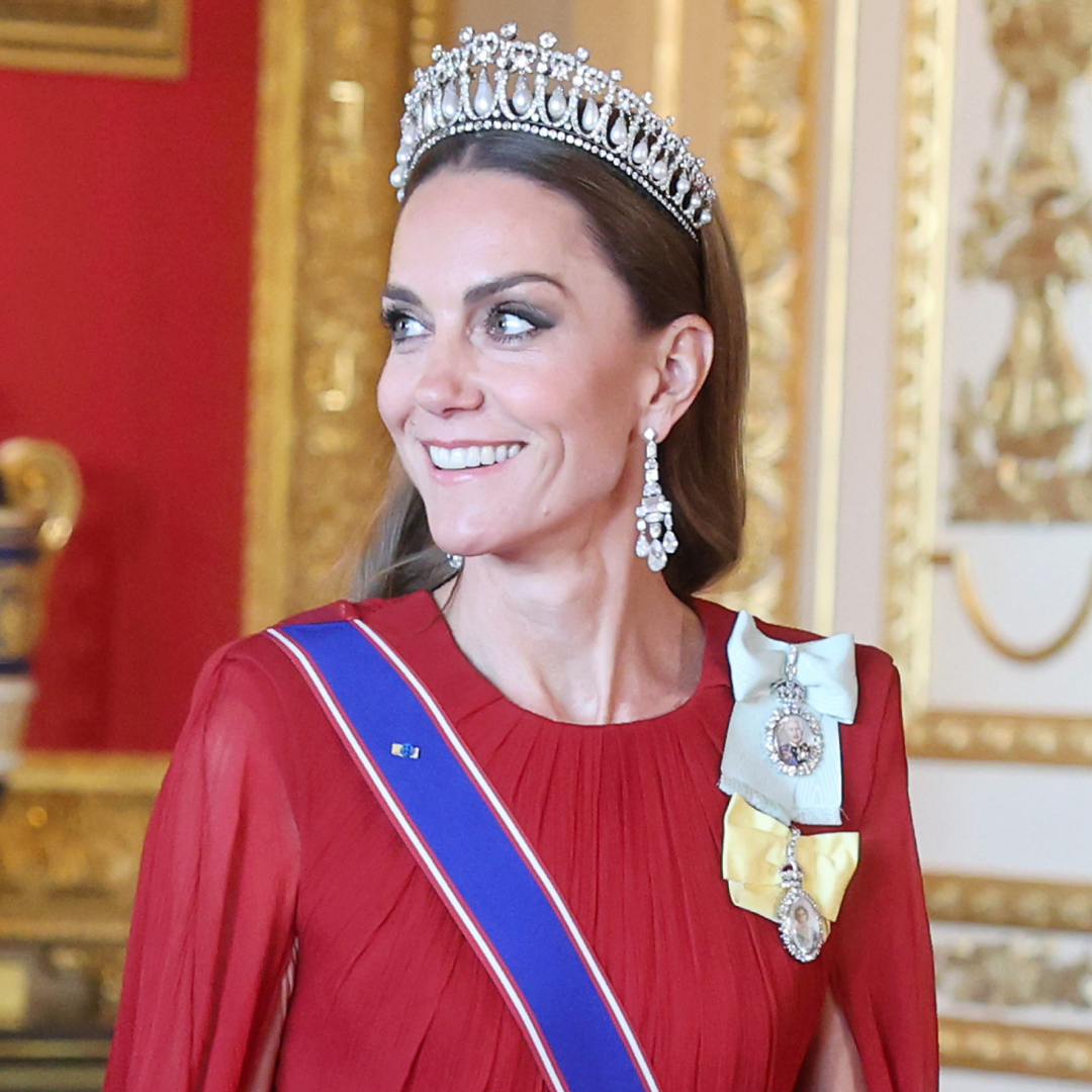 Kate Middleton wearing a red gown and tiara walking with Prince William at a state banquet