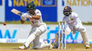 Pakistan's Abdullah Shafique (L) plays a shot as Sri Lanka's wicketkeeper Niroshan Dickwella watches