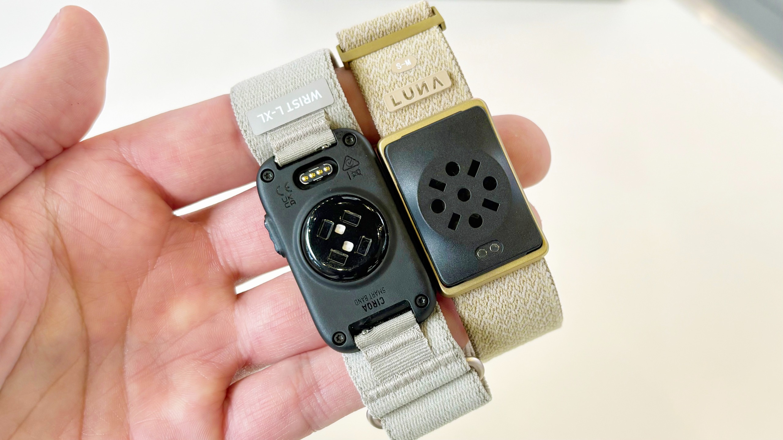 Close-up of the Garmin Cirqa screen-free tracker next to the Luna Band at IFA 2026 in Berlin