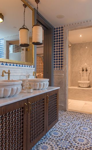 Bathroom in the Hagia Sophia Mansions hotel, Istanbul , with patterned tiled floor and decorative doors and basins